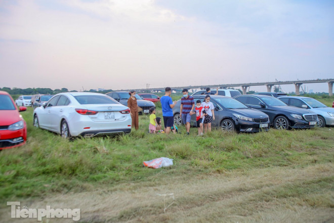 Lối đi đông nghẹt ô tô, xe máy; các khu bãi đất đều được dựng lều bạt, bếp nướng; khu vực ven sông tập trung người bơi lội, nghịch nước mà "quên" các quy định phòng chống dịch COVID-19.