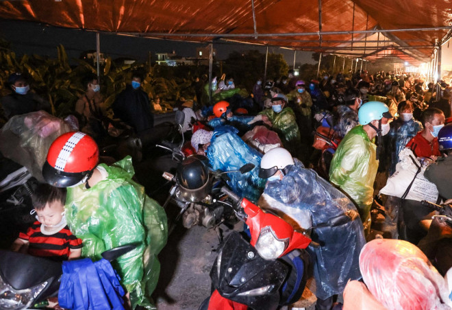 Hàng trăm người dân đi từ vùng dịch đang chờ đợi ở chốt kiểm soát dịch Covid-19 trên địa bàn huyện Phú Xuyên