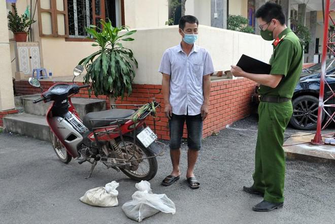 Nguyễn Văn Chức (áo cộc trắng) cùng tang vật được đưa về cơ quan công an để tiếp tục xác minh, làm rõ