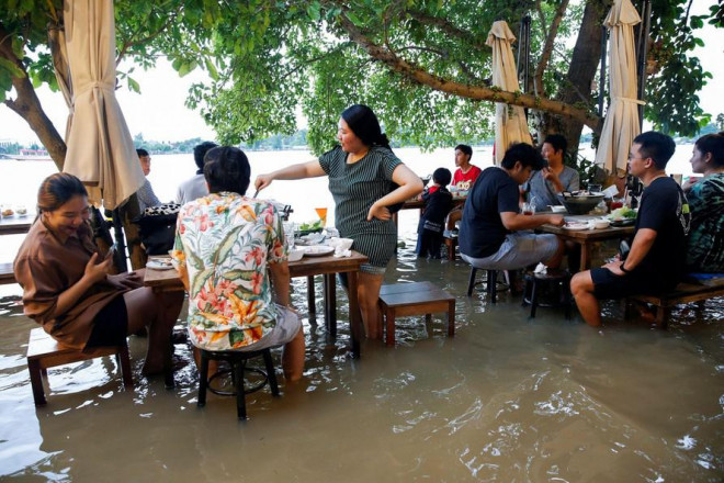 Các thực khách ngồi ăn lẩu ở nhà hàng ven sông của Jutimanon. Ảnh: Reuters