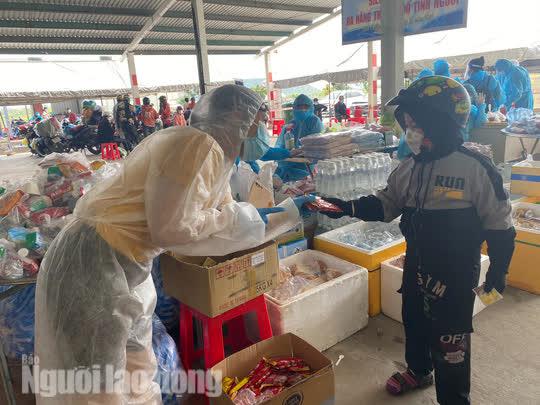 Chị Minh Hồng - Hội Phụ nữ quận Liên Chiểu phát đồ ăn vặt cho một bé trai. Chị Hồng cho hay gian hàng của Hội phụ nữ có đầy đủ những món đồ ăn cho bà con ăn tại chỗ và mang đi phòng khi đói giữa đường