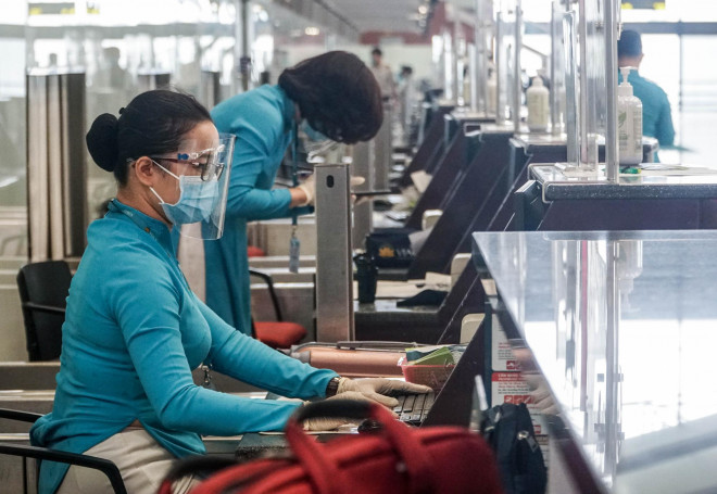 Các nhân viên Vietnam Airlines làm việc tại quầy thủ tục sân bay Nội Bài ngày 10-10