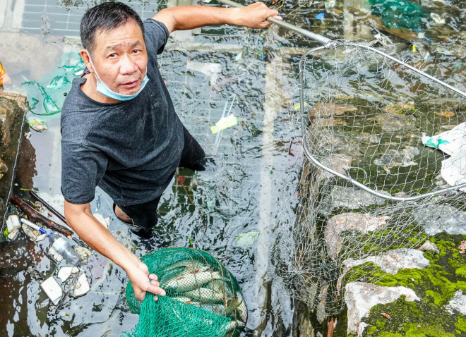 Nhiều người phấn khởi sau khi bắt được cá lớn dưới sông Tô Lịch. Mỗi con cá người dân bắt được trong sáng nay có trọng lượng từ 0,5 đến 2 kg