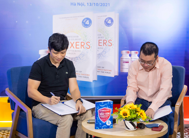 Ông Phan Minh Tâm - Chủ tịch HĐQT Công ty Cổ phần Quảng cáo Trực tuyến 24H (trái) và ông Nguyễn Cảnh Bình - Chủ tịch HĐQT Công ty Cổ phần sách Alpha (phải) kí kết hợp tác công bố xuất bản cuốn sách Vaxxers.
