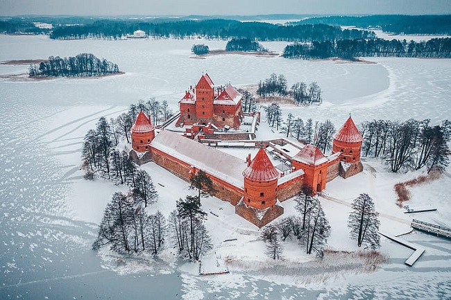 11. Lâu đài Trakai, Lithuania

Lâu đài Trakai đúng là tòa lâu đài đẹp như trong cổ tích. Nằm cách Vilnius 17 dặm về phía tây, lâu đài này dường như đã “biến hình” vào những tháng mùa đông, khi hồ nước xung quanh đóng băng và các tháp pháo màu cam lấm tấm tuyết phủ.
