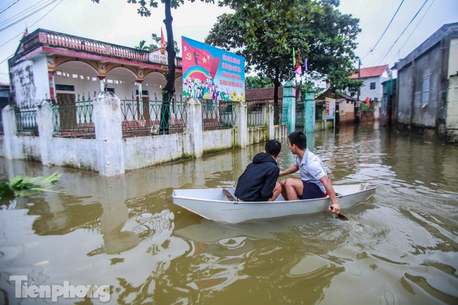 Người dân phải dùng thuyền, phao tự chế để di chuyển trong thôn.