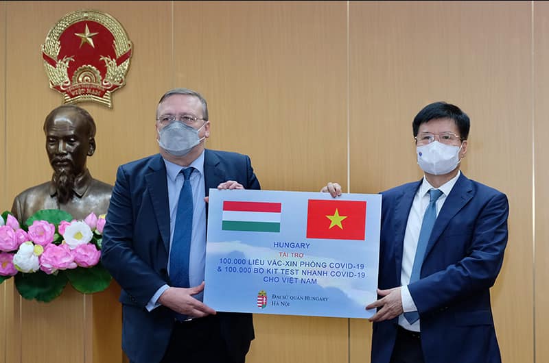 Thứ trưởng Bộ Y tế Trương Quốc Cường thay mặt lãnh đạo Bộ Y tế tiếp nhận 100.000 liều vắc-xin COVID-19 AstraZeneca và 100.000 bộ kít xét nghiệm nhanh từ ông Öry Csaba, Đại sứ Hungary tại Việt Nam.