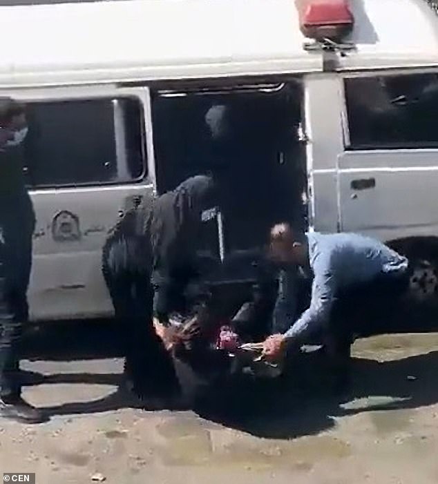 Người phụ nữ bị cảnh sát đạo đức ép đưa lên xe van.