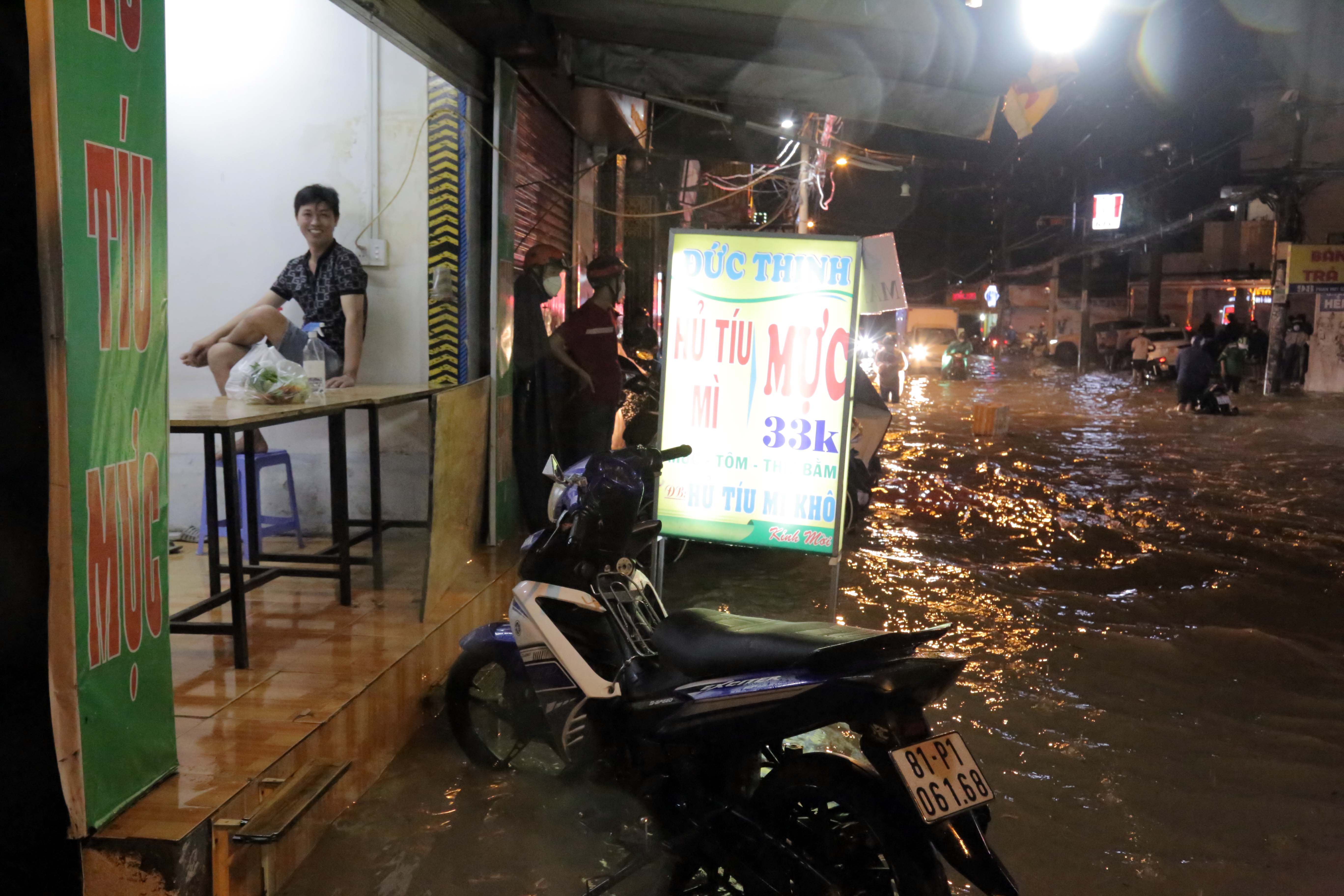 Hoạt động kinh doanh của người dân bị “đóng băng” do nước bao vây phía trước cửa hàng.