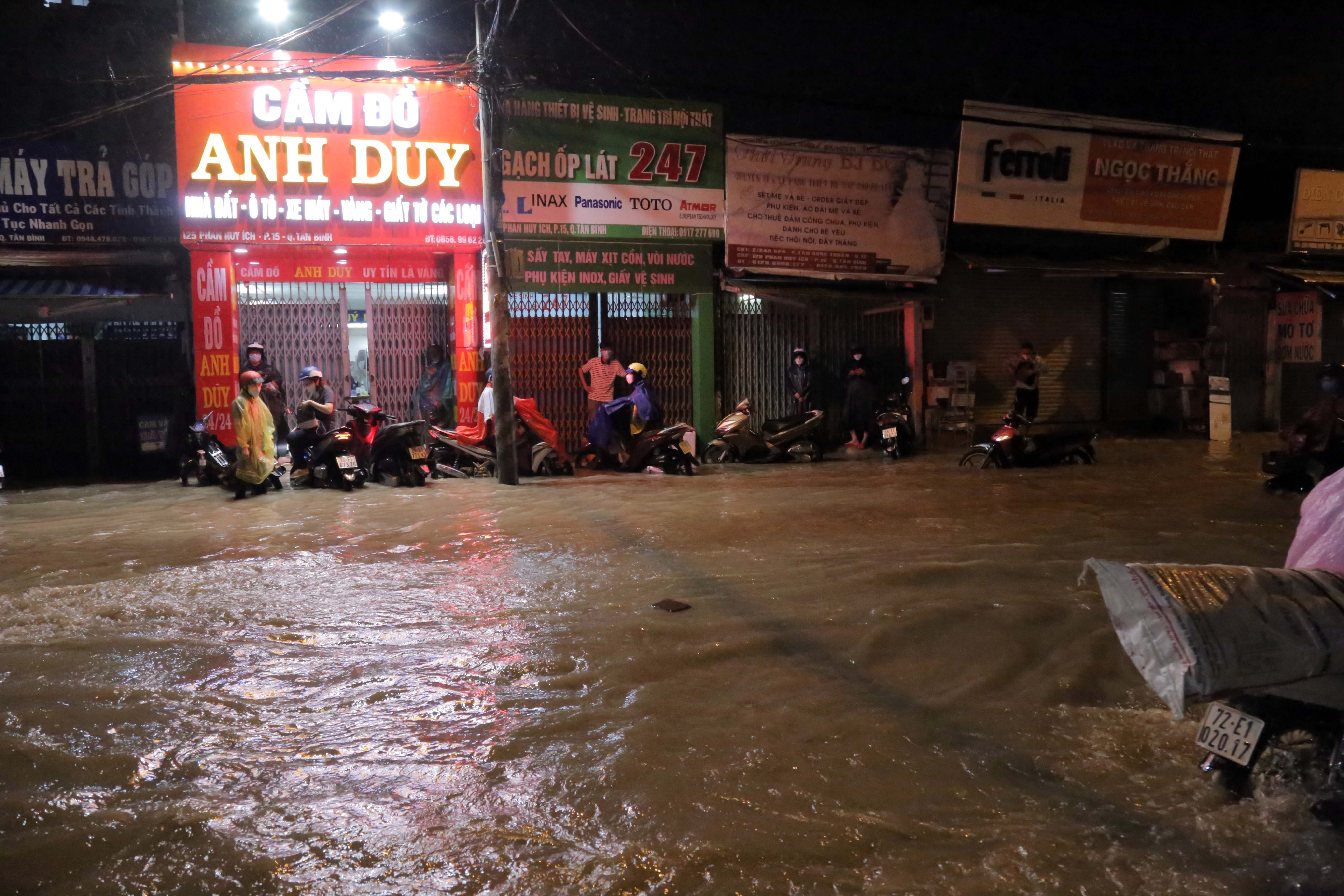 Đến 21h cùng ngày, nước trên đường Phan Huy Ích vẫn còn mênh mông. Nhiều phụ nữ gọi điện về nhà cầu cứu người thân vì xe chết máy, số khác gọi điện thông báo người nhà chưa về được vì đang bị mắc kẹt trên đường ngập.