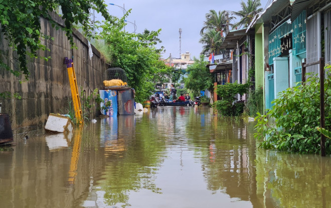 Tuyến đường dọc giữa cầu Kỳ Phú 1 và Kỳ Phú 2 bị ngập sâu, nước tràn vào nhà người dân từ đêm 23-10.