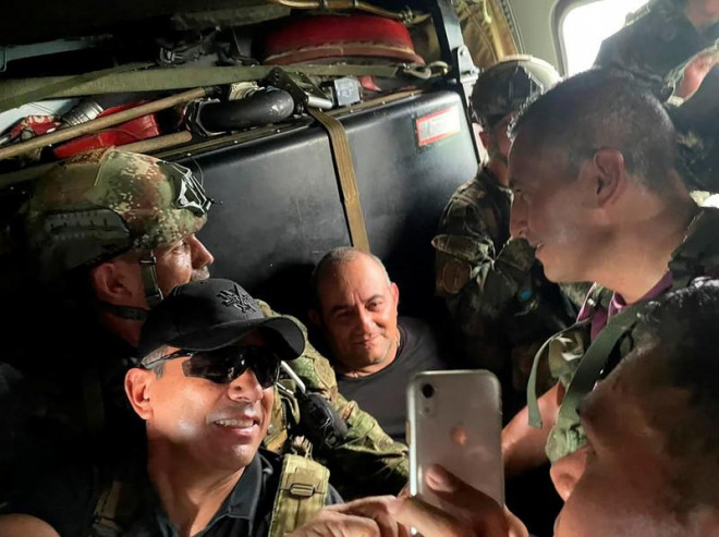 Otoniel được các binh sĩ Colombia hộ tống trên một chiếc trực thăng sau khi bị bắt. Ảnh: REUTERS