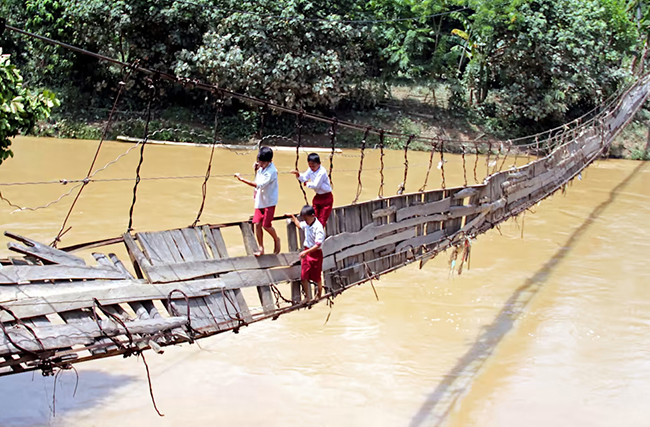 Cây cầu ván, Indonesia: Hãy tưởng tượng bạn sẽ đi như thế nào trên cây cầu treo lơ lửng này ở Indonesia? Vậy mà những đứa trẻ này vẫn hằng ngày đến trường băng qua cây cầu đáng sợ này.&nbsp;
