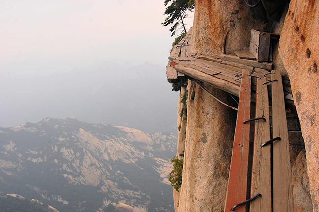 Núi Hua Shan, Trung Quốc: Leo lên đỉnh núi Hua Shan là một trong những thử thách đối với người đam mê đi bộ đường dài, với sự can đảm và tinh thần mạo hiểm. Du khách không chỉ phải đối mặt với&nbsp;vô số bậc thang được đẽo vào đá, mà còn có những tấm ván&nbsp;đóng thành lối đi hẹp và rất chênh vênh.&nbsp;
