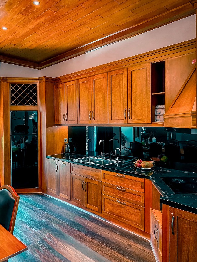 Khu vực bếp rộng rãi với hệ tủ bếp bằng gỗ được gia chủ “đo ni đóng giày” chuẩn kích thước từng món đồ gia dụng nhỏ.
