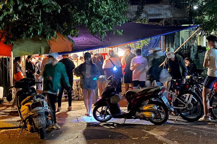 Nhiều người xếp hàng tại một quán ăn vặt vên đường Vệ Hồ (Tây Hồ, Hà Nội) lúc 22 giờ đêm.