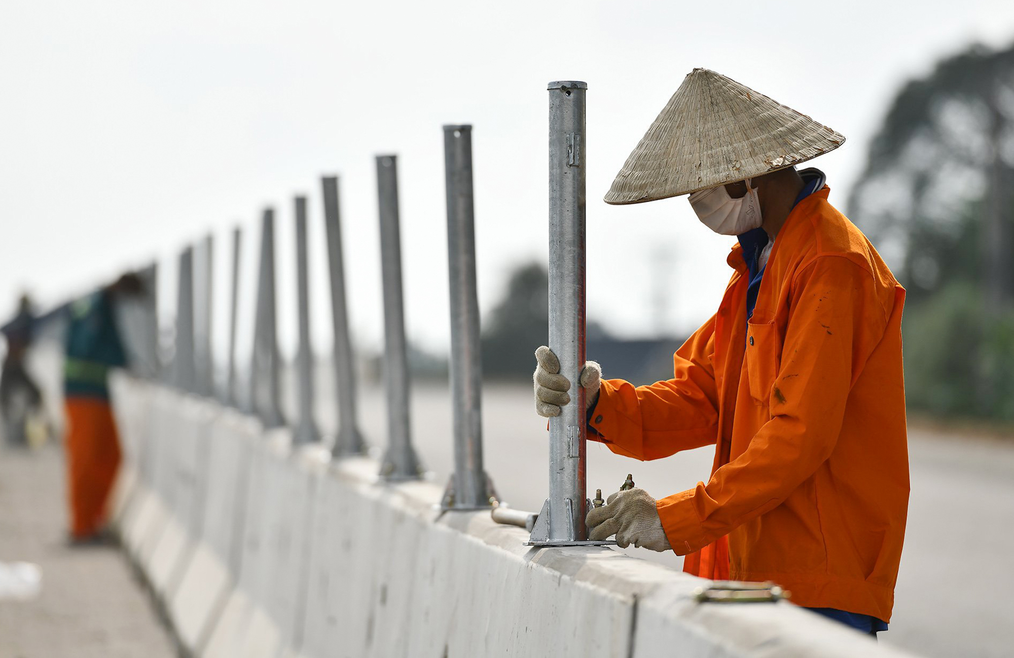 Công nhân tập trung lắp dải phân cách giữa hai hướng lưu thông của cao tốc.