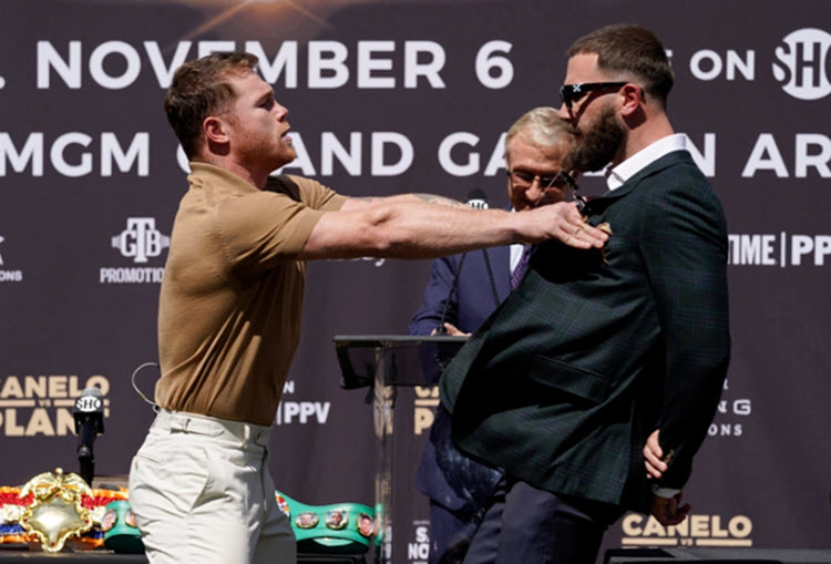 Canelo (trái) được mệnh danh "Ronaldo Boxing) xô đẩy làm rách mặt đối thủ người Mỹ Plant (phải)