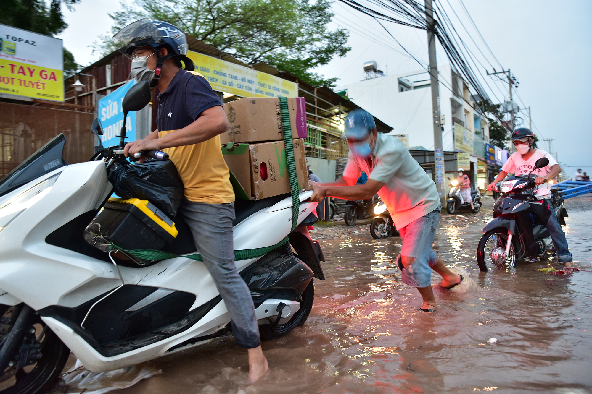 Một số người dân bên đường liên tục hỗ trợ người đi đường vượt qua ổ trâu, đẩy xe chết máy, đỡ người té ngã…