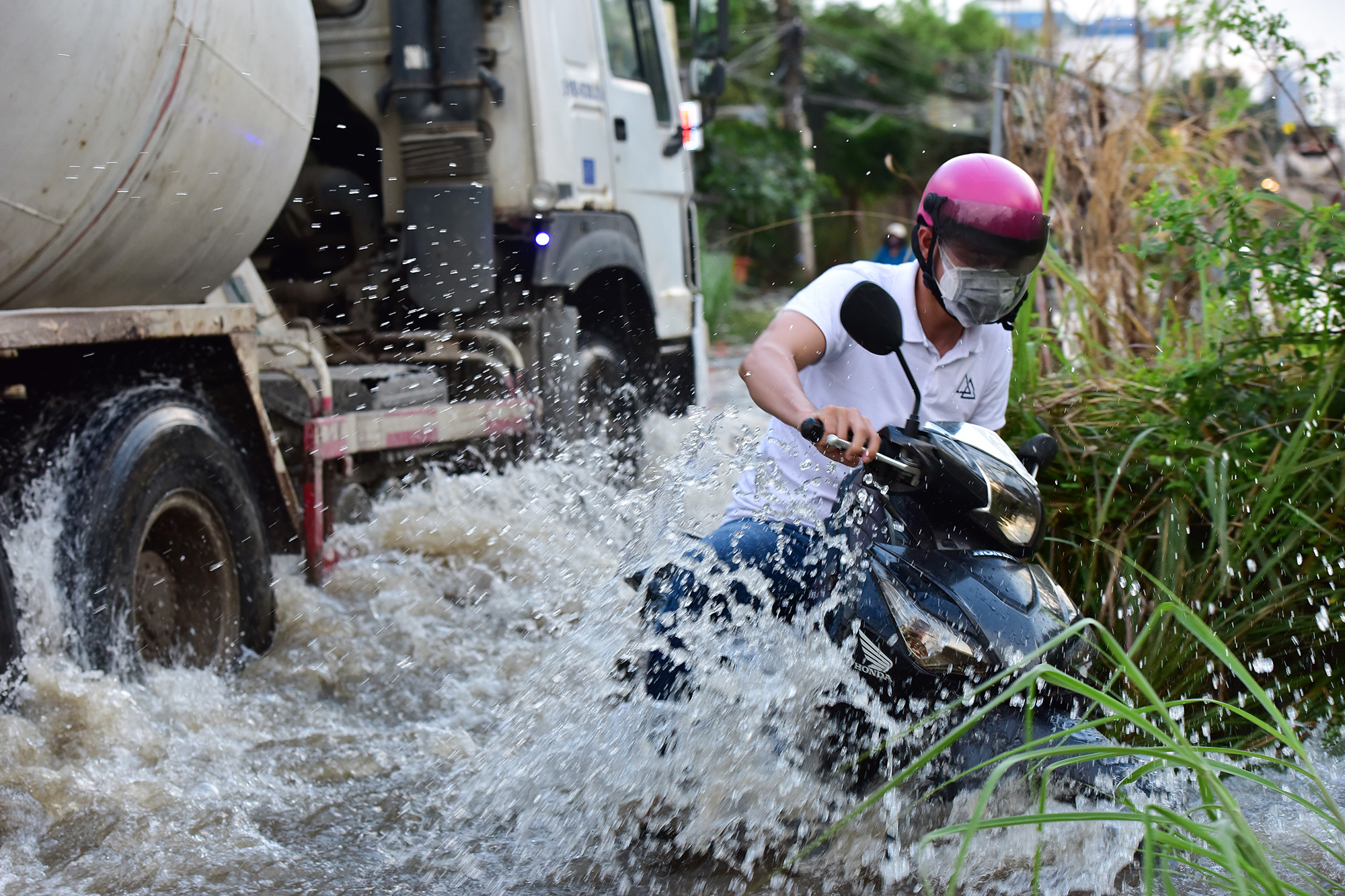 Ôtô, xe tải chạy nhanh tạo sóng nướng khiến nhiều người điều khiển xe máy loạng choạng té ngã khi bị sóng nước đánh vào.