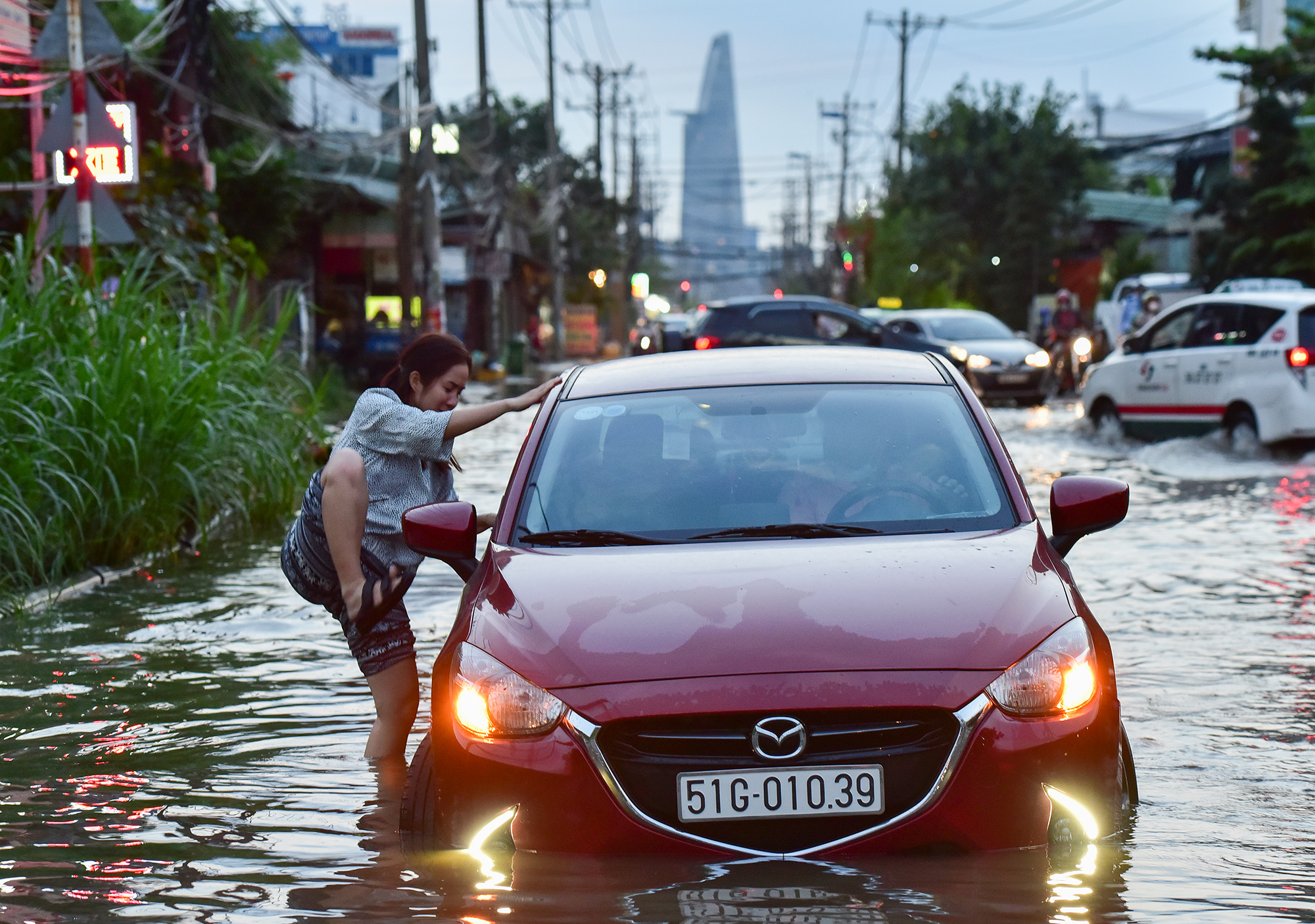 Ôtô chạy vào đoạn đường ngập sâu cũng bị chết máy, những người ngồi bên trong phải hạ kính để chui ra, tránh mở cửa nước ập vào...