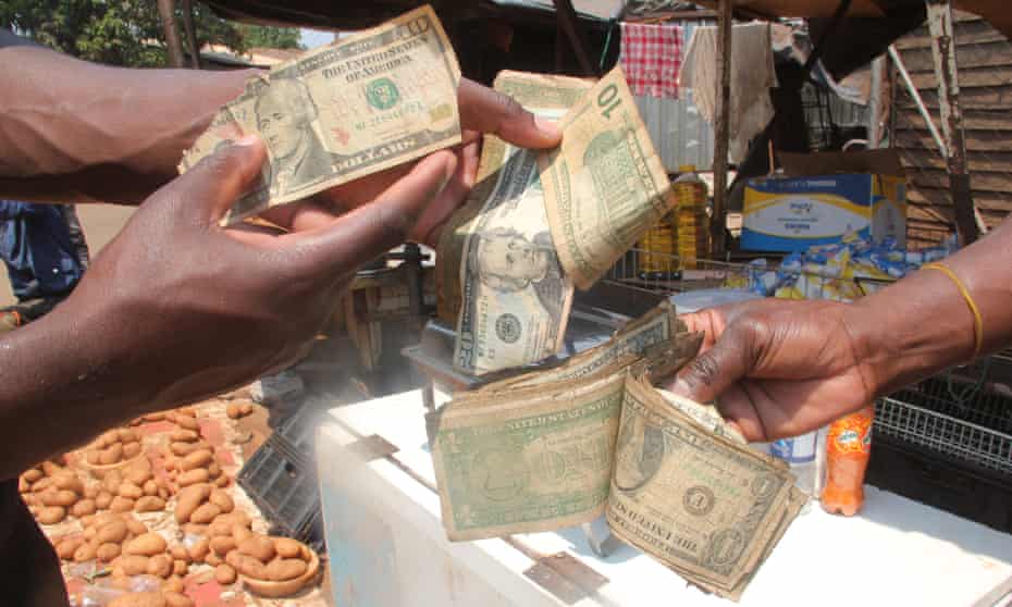 Người dân Zimbabwe tiêu xài bằng những đồng đô la Mỹ rách nát (ảnh: Guardian)