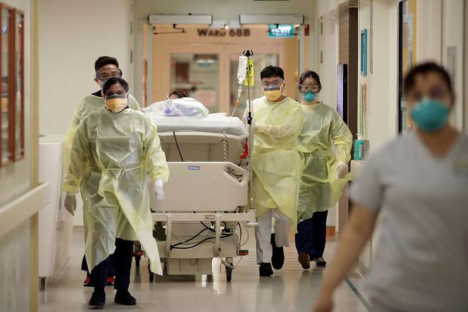 Đưa bệnh nhân COVID-19 nhập viện ở Singapore. Ảnh: THE STRAIT TIMES