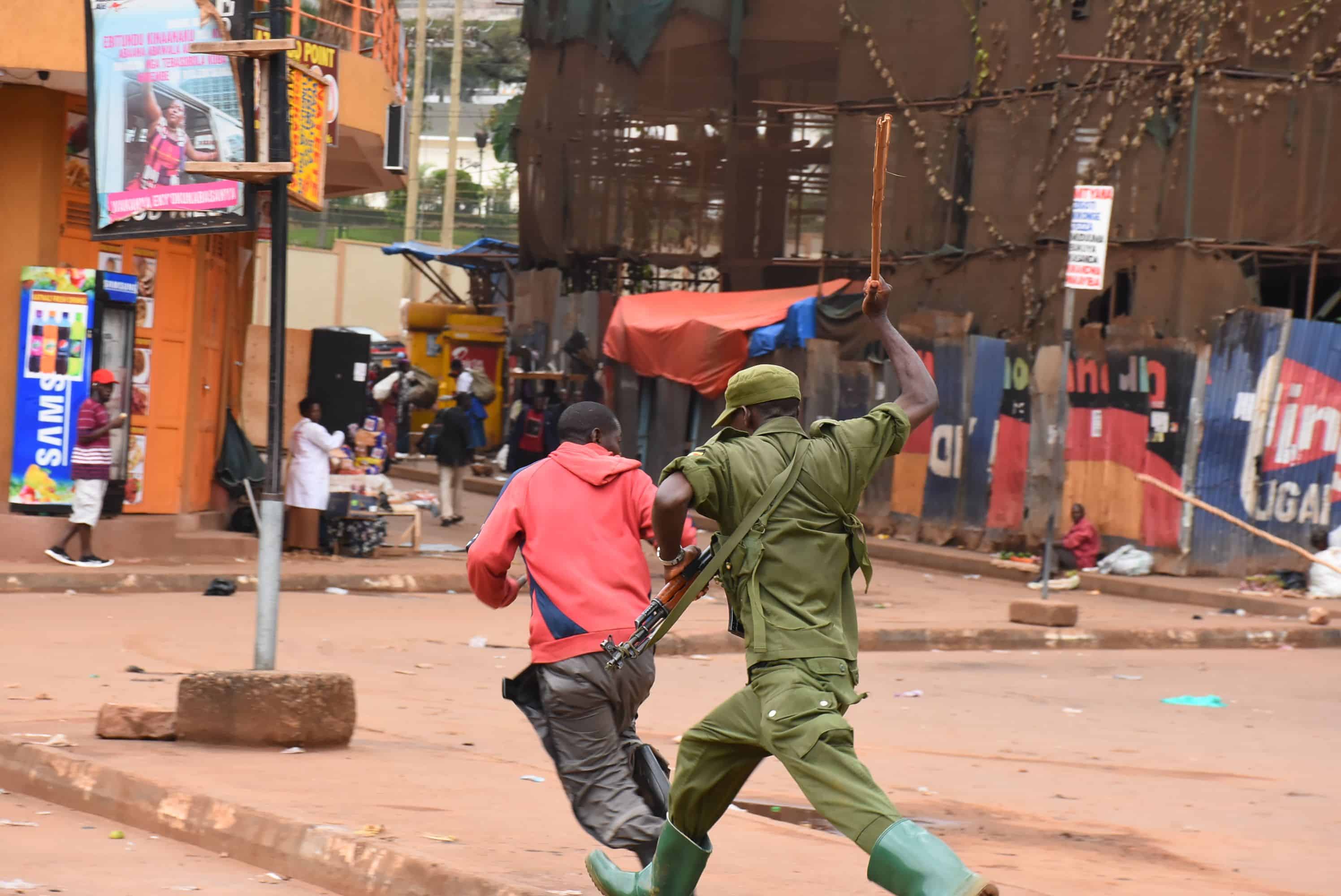 Một người vi phạm lệnh cấm ra đường bị cảnh sát đuổi ở Uganga, châu Phi. Ảnh:&nbsp;Alex Esagala