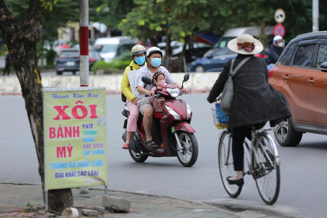 Các bạn nhỏ co ro trong gió rét khi di chuyển cùng bố mẹ.