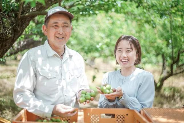 Ayaka Suita, 30 tuổi, rời công việc nhân sự ở Tokyo để chuyển về sống ở thị trấn nhỏ. Cô chụp cùng bác nông dân Yukihiro Kuroki tại vườn mận. (Ayaka Suita)