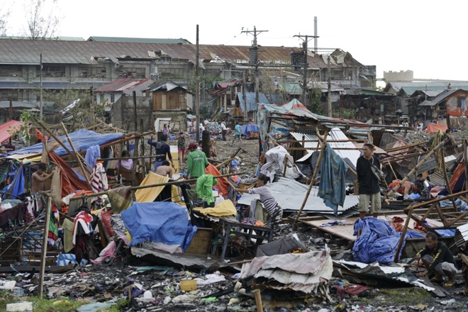 Người dân Philippines ngày 17.12 quay trở về nhà đánh giá thiệt hại do siêu bão gây ra.