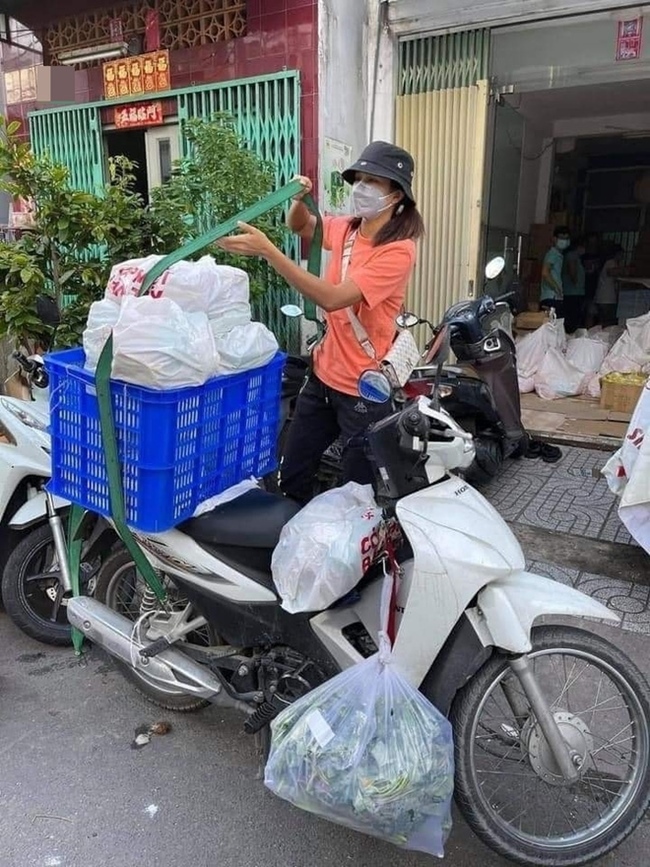 Hoa hậu H&#39;Hen Niê tự bê các thùng đồ, buộc chặt phía sau xe máy. Đằng trước, xe của cô cũng &#34;thồ&#34; đủ các loại túi rau, hoa quả. Đây là hình ảnh H&#39;Hen Niê đi chợ giúp bà con mùa dịch vào mùa hè vừa qua.&nbsp;
