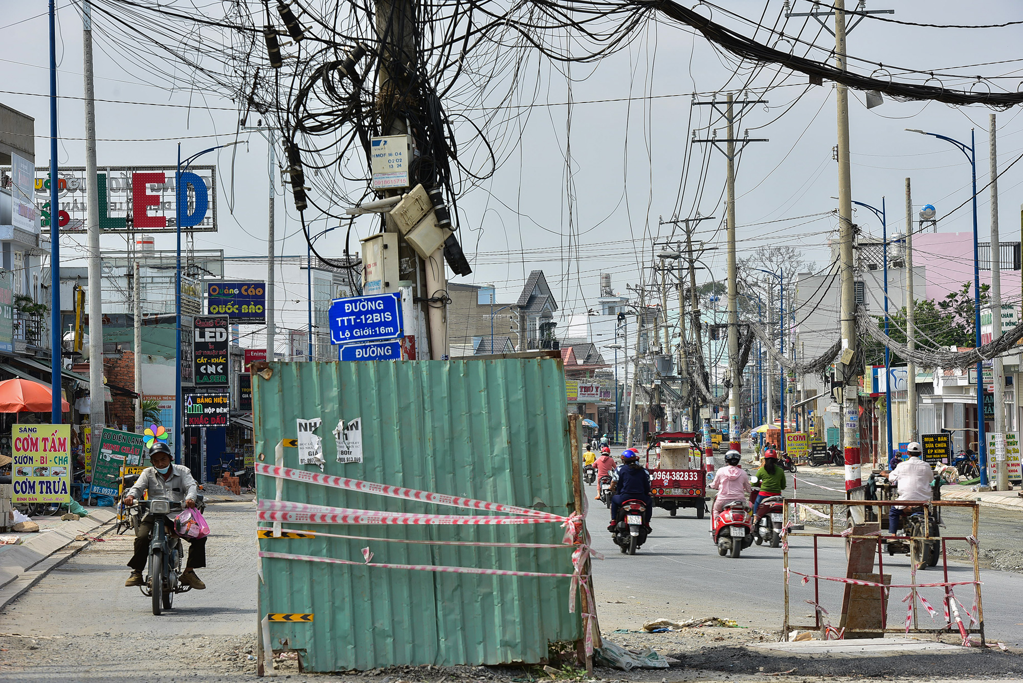 Các bảng tên đường, hẻm, biển báo giao thông trước đây nằm bên vỉa hè nay "đi lạc" xuống lòng đường mới.