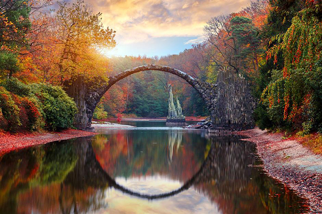 Rakotzbrücke, Gablenz, Đức: Cây cầu ấn tượng&nbsp;này ở công viên Kromlauer có biệt danh là cầu Quỷ. Truyền thuyết kể rằng, cây cầu&nbsp;uốn cong theo hình bán nguyệt hoàn hảo, phản chiếu xuống mặt nước tĩnh lặng bên dưới do Satan xây dựng nhằm bắt lấy linh hồn của những người leo qua cây cầu.&nbsp;
