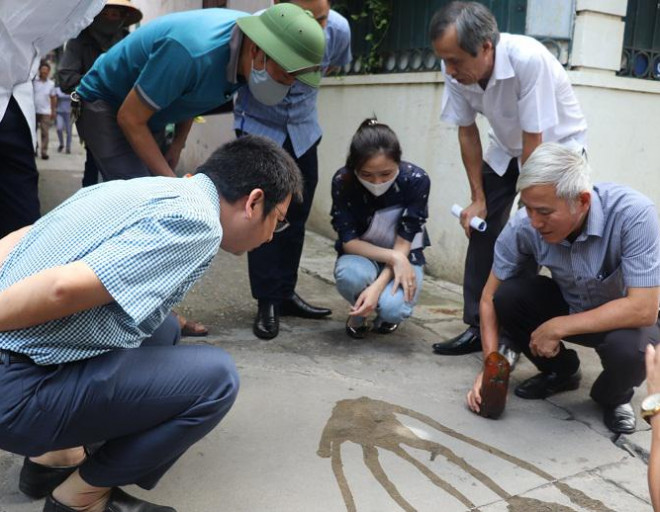 Lãnh đạo CDC Hà Nội kiểm tra dụng cụ chứa nước có bọ gậy tại huyện Thanh Trì. Ảnh TL