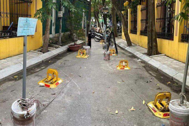 Cọc cấm cùng khoá bẫy đỗ xe được lắp dưới lòng đường ở một con ngõ ở Hà Nội