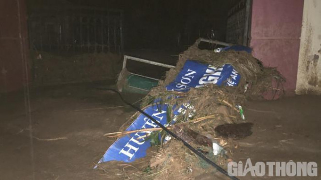 Nước lũ kéo đổ sập cánh cổng của một đơn vị ở thị trấn Mường Xén chìm xuống đất