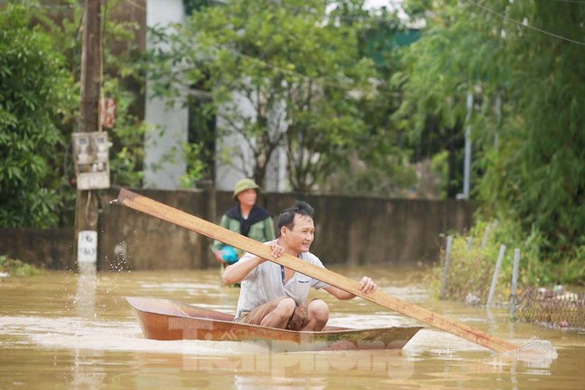 Người dân di chuyển bằng thuyền tôn vùng bị ngập lụt 