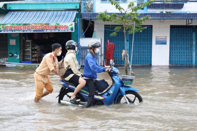 Công an Cần Thơ đội mưa, lội nước giúp người dân &#34;vượt sông&#34; trong thành phố - 5