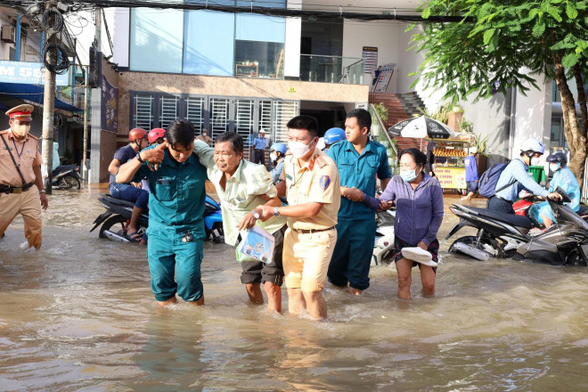 Cụ ông đi khám được lực lượng chức năng hỗ trợ sang đường để vào bệnh viện.