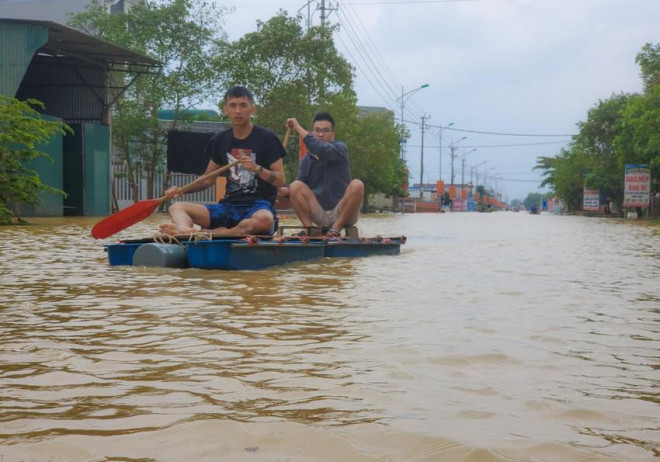 Người dân dùng bè, di chuyển trên Quốc lộ 9C. Ảnh: BT