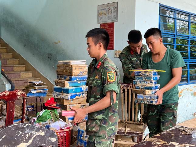 Không ngại khó khăn, lực lượng quân đội xung phong làm việc nặng, bưng bê nhiều đồ đạc dính bùn.