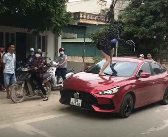 Người phụ nữ nhảy lên nắp capo đạp vỡ kính ô tô (ảnh cắt từ clip)