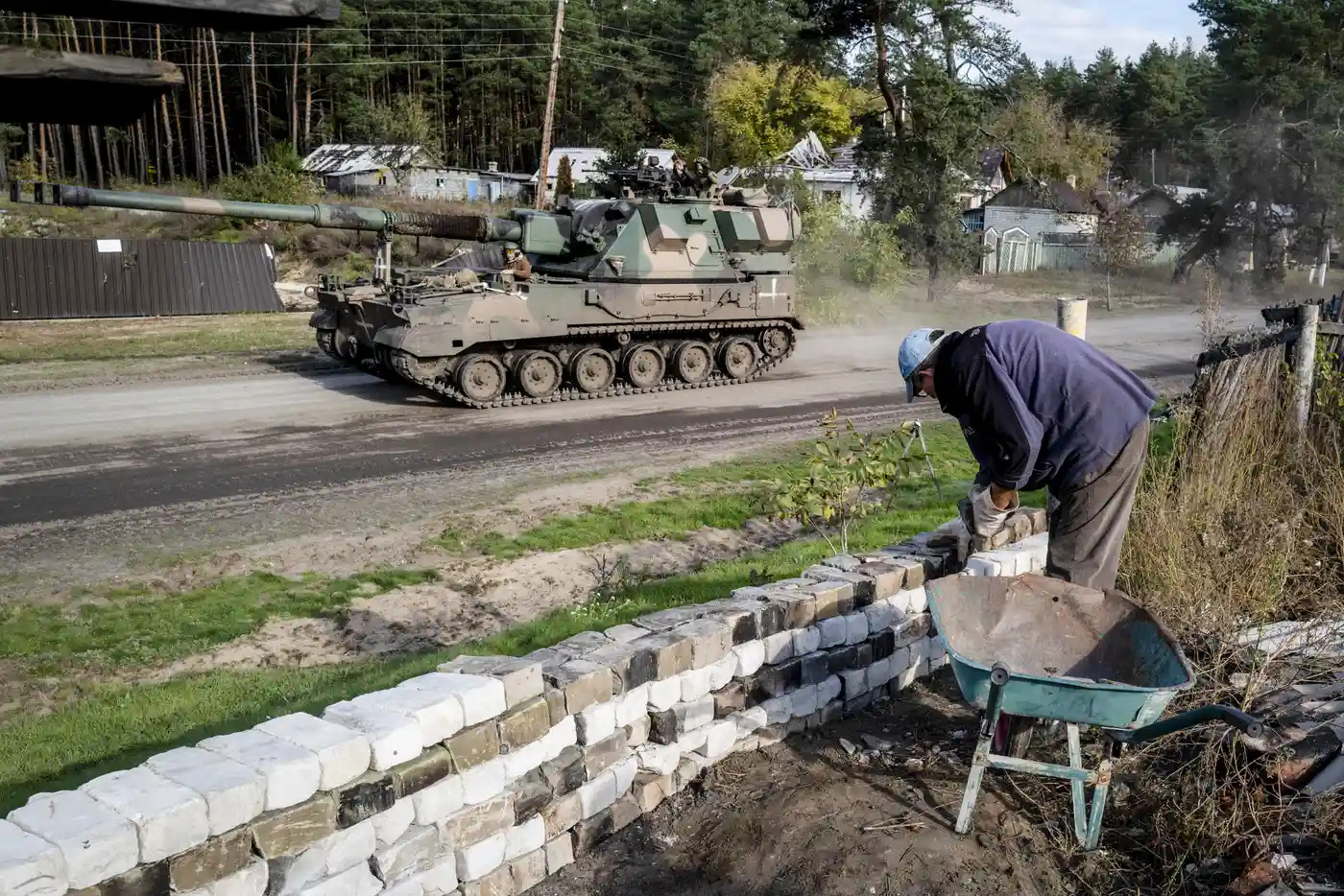 Dân Ukraine xây tường rào khi xe tăng đi lại trên đường (ảnh: CNN)