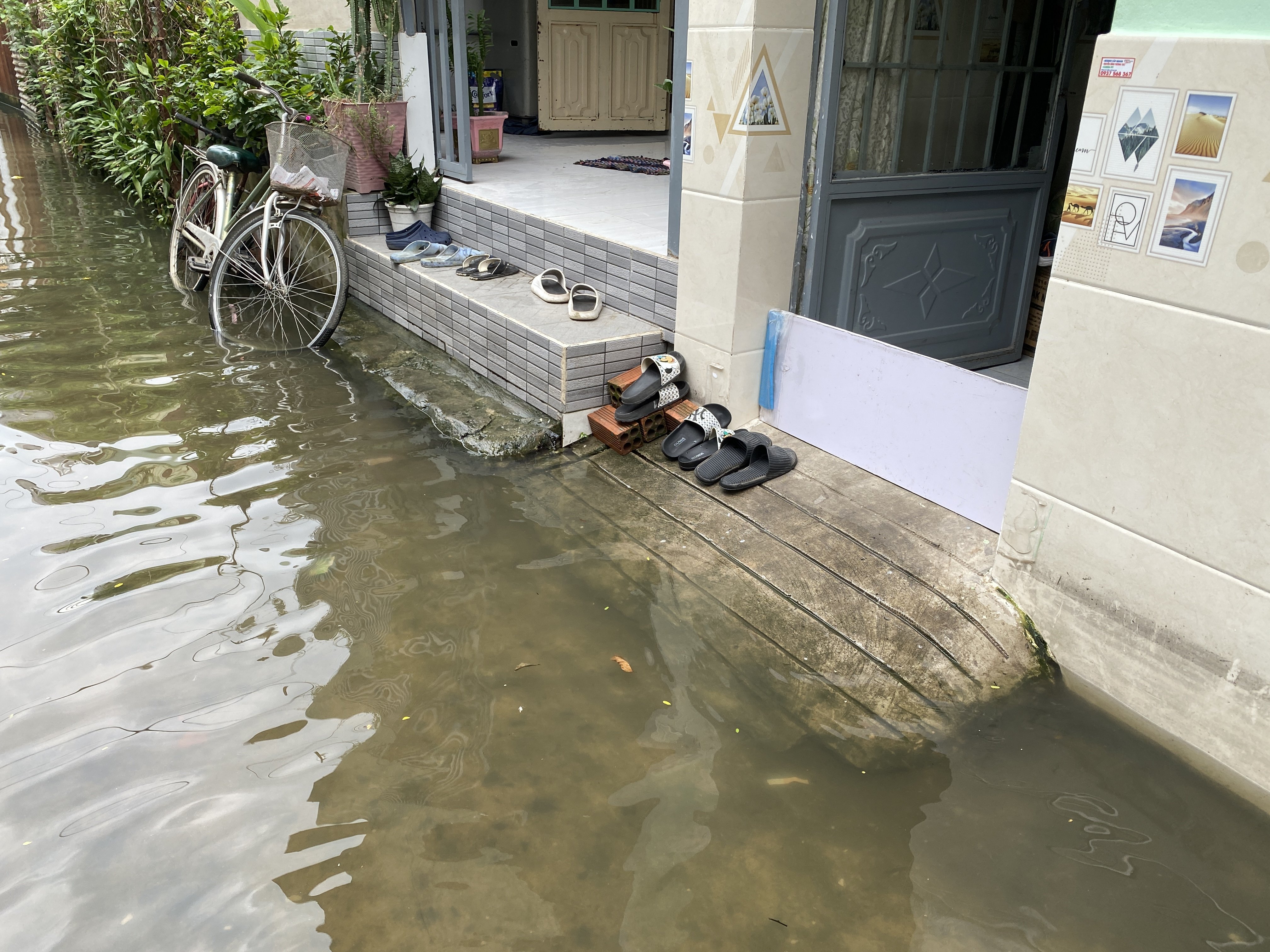 Nước bao vây phía trước nhà. Nhiều nhà dân phải “đắp đê” để ngăn nước tràn vào.