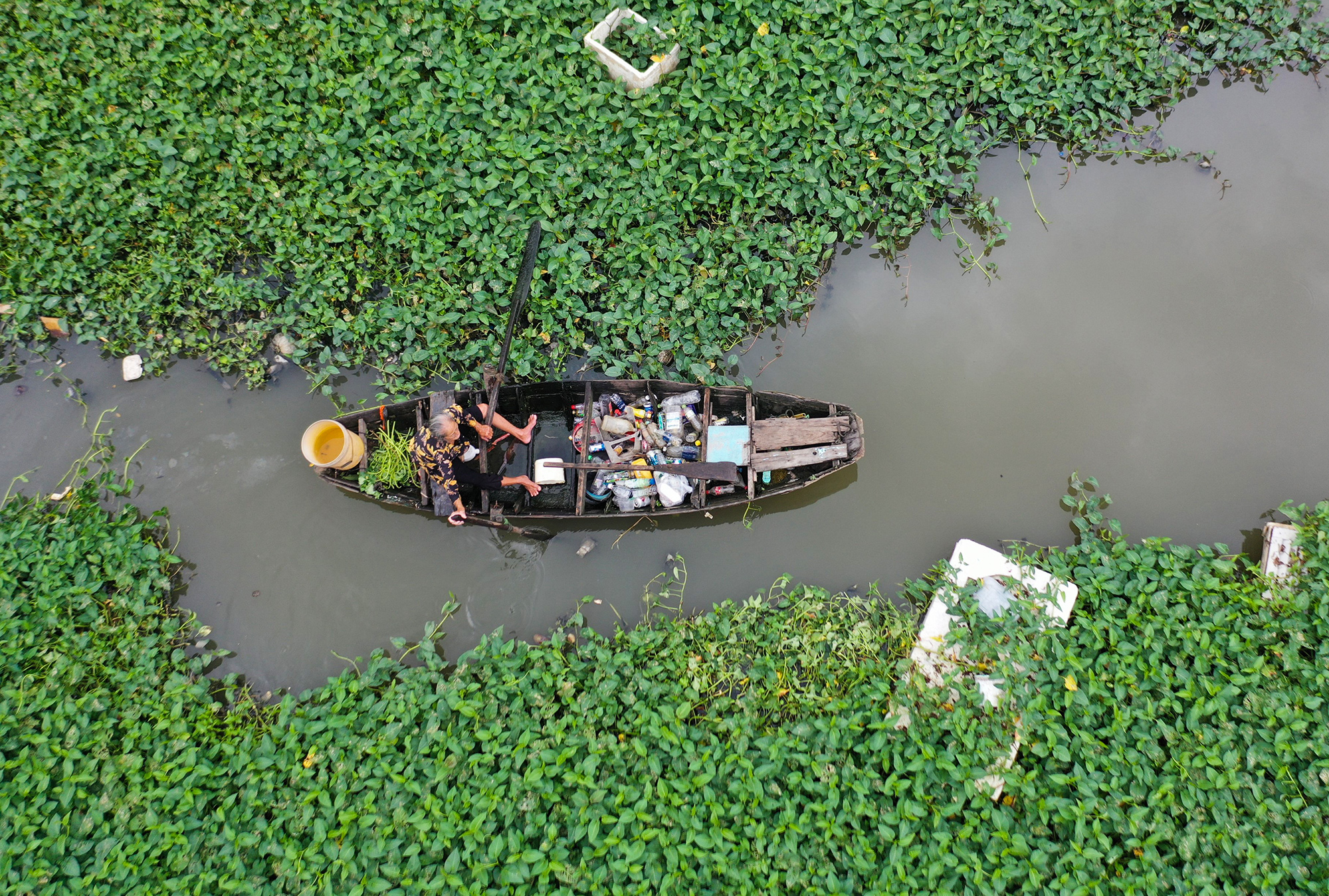 Sau nhiều giờ chèo thuyền nhặt vớt, khoang chứa khá nhiều ve chai, cụ bà chèo thuyền trở về chòi. “Con rạch này cứ sáng ra là xuất hiện nhiều rác, đồ nhựa do người dân sinh sống hai bên đông đúc. Sức khoẻ không cho phép để nhặt hết, nên thấy đủ là tôi về”, cụ Nhời nói.