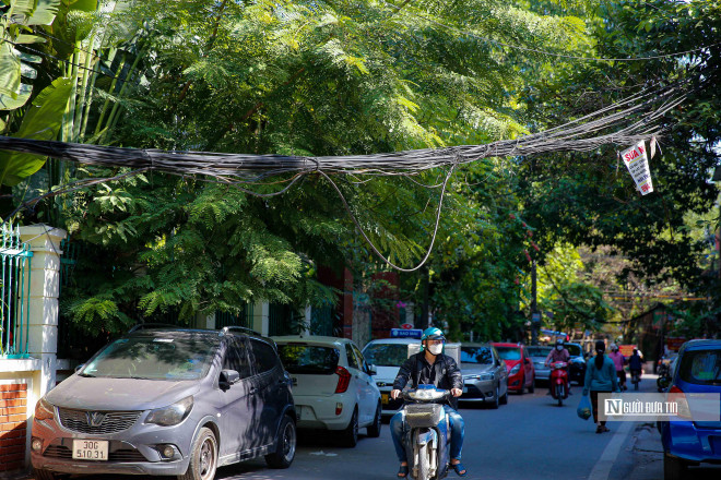 Hình ảnh dây cáp viễn thông bị chùng xuống sát đầu người đi đường không còn quá xa lạ với người dân Thủ đô. Trong ảnh là khu Trung Tự (quận Đống Đa).