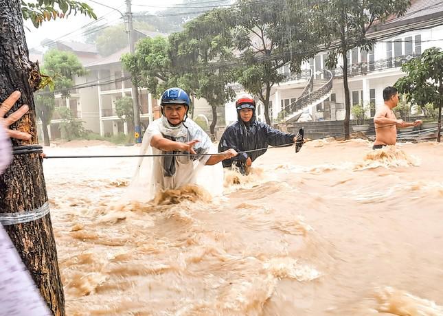 Người dân phải căng dây hỗ trợ người đàn ông qua đường. Ảnh: Trương Định