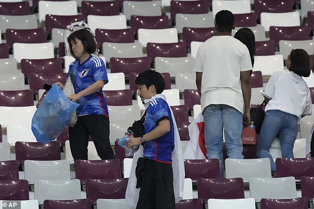Cổ động viên Nhật Bản dọn rác trên sân vận động quốc gia Qatar sau chiến thắng 2-1 của ĐT Nhật Bản trước ĐT Đức.