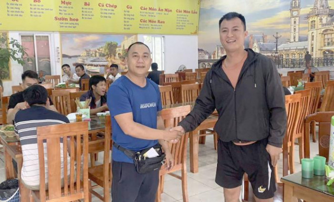 Anh Hoàng (trái) vui vẻ gặp gỡ, chuyện trò với các tài xế tại quán ăn của mình
